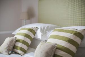 uma cama com almofadas verdes e brancas em Grays Boutique B&B em Bath