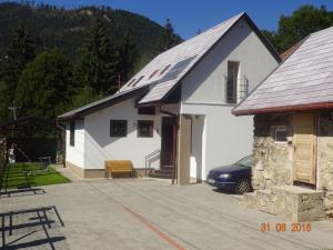 a white house with a car parked in front of it at Chalupa pri vodopade in Lúčky