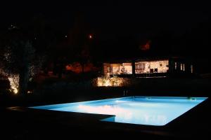 a swimming pool in front of a house at night at Sete Quintas in Miranda do Corvo