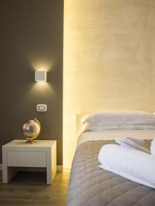 - une chambre avec un lit et une table de chevet dans l'établissement La Banchina Holiday Rooms, à Trani