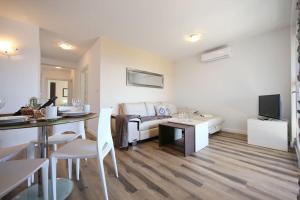 a white living room with a couch and a table at Oleandra Apartments in Drage