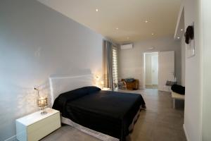 a bedroom with a black bed in a room at Palazzo al Carmine Dimora Storica in Castelvetrano Selinunte