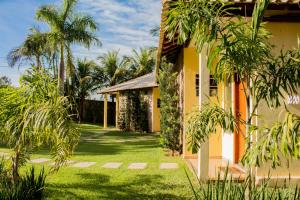 a yellow house with palm trees in the yard at Pousada Recanto Do Sussego in Olímpia