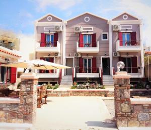 a large house with an umbrella and a patio at Victoria Studios in Panagioúda