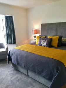 
a hotel room with a bed, chair, and nightstand at Hazelbrook Killarney in Killarney
