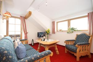 a living room with a couch and two chairs and a table at Gästehaus am Berg in Hirschegg