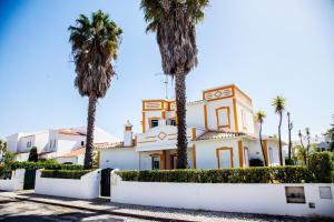 uma casa com palmeiras em frente em Villa Clara Premium by Sunny Deluxe em Albufeira