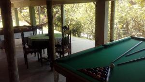 a pool table in a room with a table and chairs at Sítio Cumuru in Paraty