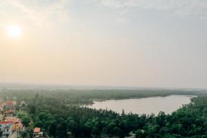 - une vue sur une rivière avec des arbres et des bâtiments dans l'établissement Vinh Hoang Hotel, à Dong Hoi