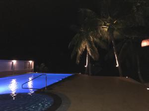 a swimming pool at night with palm trees at Marina Beach Resort - SHA Extra Plus in Lamai