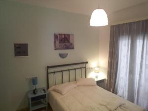 una camera da letto con un letto con lenzuola bianche e una luce di Very-Kokkos Pension 2 a Naxos Chora
