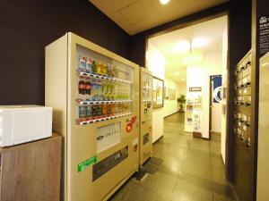 um quarto com um frigorífico com bebidas em Hotel Route-Inn Iwakiizumi Ekimae em Iwaki