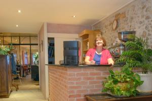 a woman standing behind a counter in a kitchen at Logis Hotel Restaurant de la Montagne Noire in Dourgne