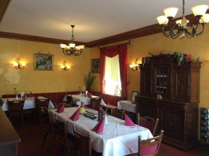 a dining room with tables with pink napkins on them at Moselhotel Lesura in Lieser