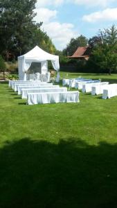 a row of white tables and chairs in a field at "Wendezeller Stuben" Weymann Gastronomiebetriebs GmbH in Wendeburg