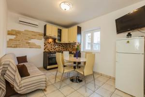 a kitchen and living room with a table and a refrigerator at Apartments Antonio in Makarska