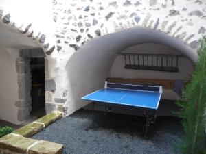 a blue ping pong table sitting in a tunnel at Les quatre provinces d'Irlande in Saint-Amant-Tallende
