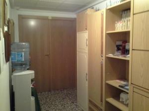 a small room with a kitchen with a refrigerator and a door at Pensión Lacasta in Zaragoza