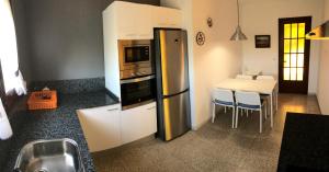 Il comprend une cuisine équipée d'un réfrigérateur et d'une table avec des chaises. dans l'établissement Mas Tauler, à Sant Antoni de Calonge