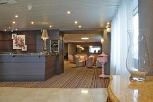 a lobby of a hotel with a bar and chairs at Hôtel Croix des Bretons - Lourdes Pyrénées in Lourdes