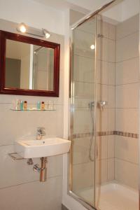a bathroom with a shower, sink, and mirror at Hostal Ripoll Ibiza in Ibiza Town
