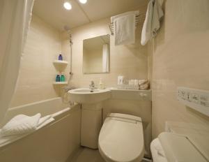 a white bathroom with a toilet and a sink at Red Roof Inn Kamata / Haneda Tokyo in Tokyo