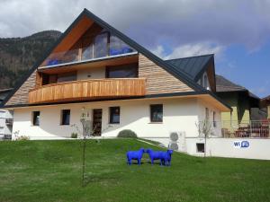 two blue statues in front of a house at La Marmote Albergo Diffuso di Paluzza Testeons in Paluzza