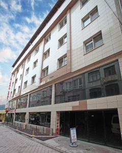 a large white building with windows on a street at Yildizoglu Hotel in Samsun