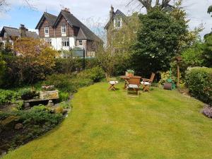 a garden with a table and chairs in the grass at Baytree House in Harrogate