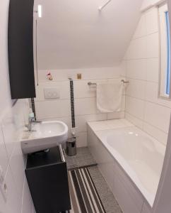Baño blanco con bañera y lavamanos en Suite mit Blick auf die Lichtentaler Allee en Baden-Baden