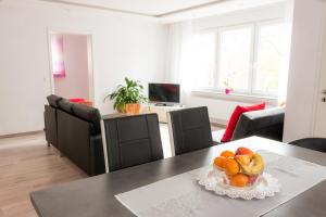 ein Wohnzimmer mit einem Tisch und einer Obstschale in der Unterkunft Suite mit Blick auf die Lichtentaler Allee in Baden-Baden