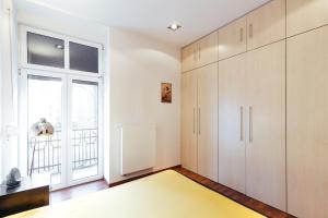 a room with white cabinets and a large window at Apartment In The Strict City Centre in Łódź