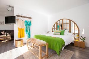 ein Schlafzimmer mit einem großen Bett und einer grünen Decke in der Unterkunft Lukanda Arenal in Sevilla