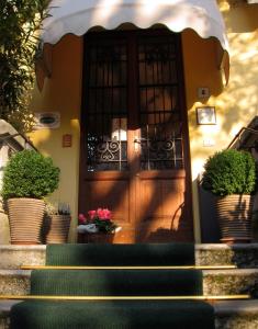 a front door of a house with potted plants at Hotel Giglio in Salsomaggiore Terme