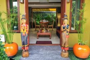 dos estatuas delante de una puerta con una mesa en Villa Amber, en Laem Set Beach 31 fotos más