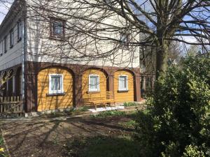 Una casa amarilla con un árbol delante. en Romantik pur en Leutersdorf
