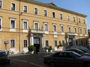 a large building with cars parked in a parking lot at Il Vicolo 48 in Pesaro