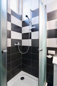 リヴィウにあるApartment Grebinky 9の黒と白のタイル張りのバスルーム(シャワー付)