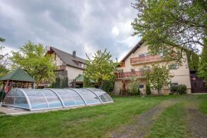 a greenhouse in a yard in front of a house at Sándor Apartman in Balatonfüred