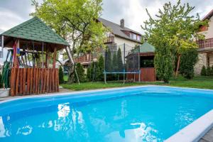 a swimming pool in front of a house with a gazebo at Sándor Apartman in Balatonfüred