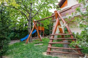 a group of wooden play equipment in a yard at Sándor Apartman in Balatonfüred