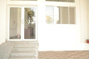 una porta a vetri aperta con scale che la conducono di Alok House a Bodh Gaya