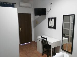 Habitación con escritorio, espejo y silla. en Parrilla Venta el Andaluz, en Conil de la Frontera