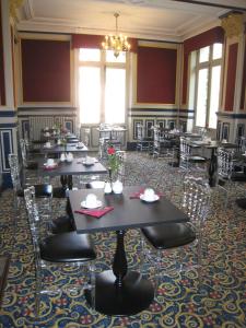 jadalnia ze stołami i krzesłami oraz żyrandolem w obiekcie Hôtel Les Maréchaux w mieście Auxerre