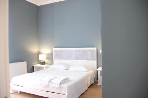 a bedroom with a white bed with two white towels at Residenza del Maestro in Matera