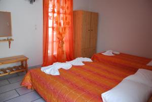 two beds in a room with towels on them at Koulas Pension - Red Lake in Agios Prokopios