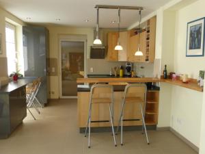 a kitchen with a counter and stools in it at K-Haus Sankt Aldegund in Sankt Aldegund