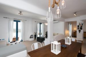 Psarou Summer Villas في بسارو: غرفة معيشة مع أريكة بيضاء وطاولة