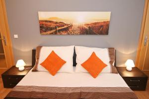 プラハにあるStyle Apartmentのベッドルーム1室(オレンジと白の枕が備わるベッド1台付)