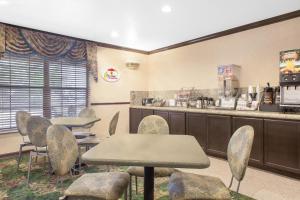 a waiting room with tables and chairs and a counter at Super 8 by Wyndham Corpus Christi in Corpus Christi